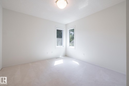 Neutral wall color, wall-to-wall carpeting, recessed lighting fixture, and two windows providing natural illumination - 14 Highlands Place, Wetaskiwin, AB 
