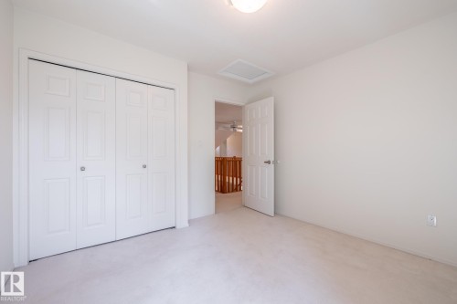 Soft neutral carpet, white walls, and a bi-fold closet door - 14 Highlands Place, Wetaskiwin, AB 