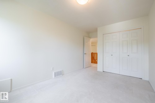 Wall-to-wall carpeting, bi-fold closet doors, and light fixture - 14 Highlands Place, Wetaskiwin, AB 