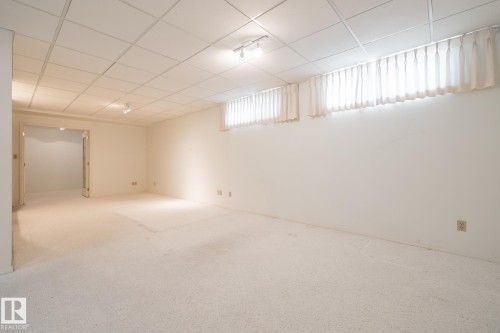 Recessed lighting with track fixtures, drop ceiling, wall-to-wall carpeting, and multiple windows with privacy coverings - 14 Highlands Place, Wetaskiwin, AB 