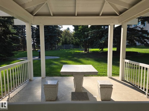 White gazebo with a concrete floor, built-in balusters, and a solid roof structure - 14 Highlands Place, Wetaskiwin, AB 