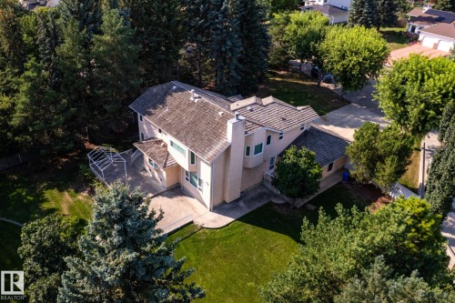 Exterior stucco siding with multiple windows, concrete patio, and fenced perimeter - 14 Highlands Place, Wetaskiwin, AB 
