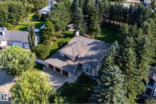Expansive lot with mature trees, a multi-car driveway, attached garage, and dormer window - 14 Highlands Place, Wetaskiwin, AB 