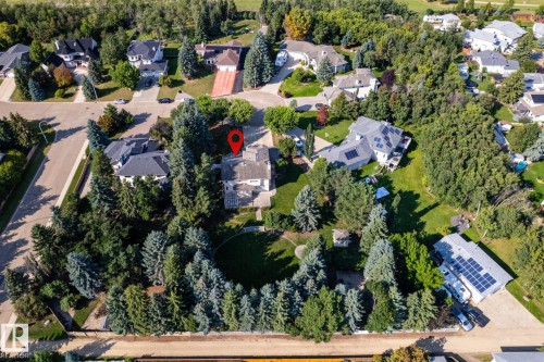 Expansive lot with mature trees and established landscaping, featuring a primary residence and a secondary structure with rooftop solar panels - 14 Highlands Place, Wetaskiwin, AB 