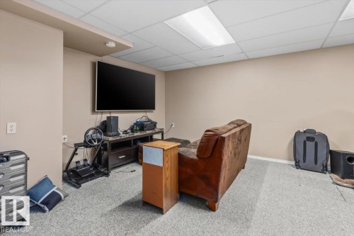Recessed ceiling lighting, wall-mounted television, neutral wall color, and carpet flooring - 8015 158 Ave Nw, Edmonton, AB 