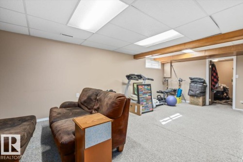 Recessed ceiling lighting, light-colored carpeting, exposed wood ceiling beams, and neutral wall tones - 8015 158 Ave Nw, Edmonton, AB 
