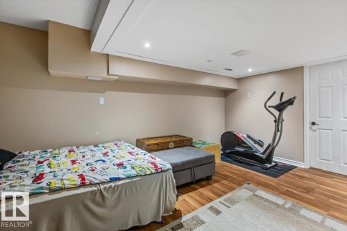 Recessed lighting, wood-finish flooring, white paneled door, neutral wall color, and a finished ceiling - 8015 158 Ave Nw, Edmonton, AB 