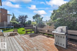 Expansive wood deck with built-in bench seating, leading to a green lawn area - 