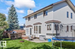 Expansive green lawn with a tiered wood deck, concrete patio, and a fire pit - 