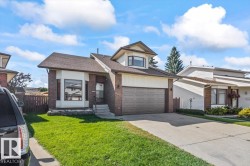 Brick and siding exterior with a peaked roofline, front-facing garage, and concrete driveway - 