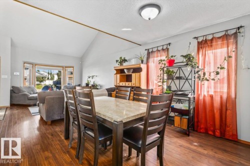 Vaulted ceiling, wood-finish flooring, bay window, and a built-in cabinet with open shelving - 8015 158 Ave Nw, Edmonton, AB 