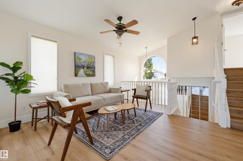 Vaulted ceiling with a ceiling fan, recessed lighting, wood-finish flooring, and a decorative arched window - 839 Blacklock Way Sw, Edmonton, AB 