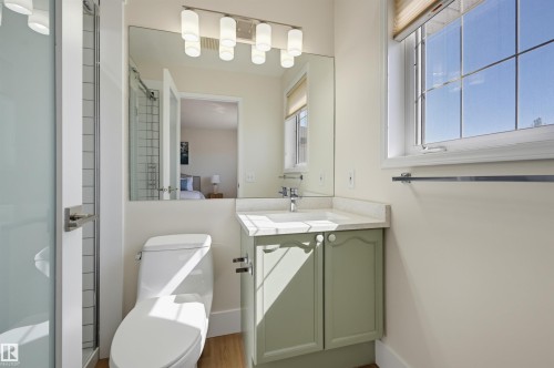 Enclosed glass shower stall, single vanity with light green cabinetry, white countertop, and a window with natural light - 839 Blacklock Way Sw, Edmonton, AB 