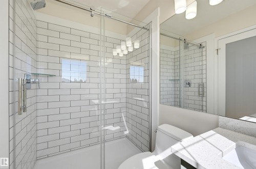 Shower with subway tile surround, glass enclosure, and rainfall shower head - 839 Blacklock Way Sw, Edmonton, AB 