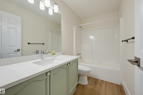 Bathroom with a built-in vanity featuring a light green finish, integrated sink, and a speckled white countertop - 839 Blacklock Way Sw, Edmonton, AB 
