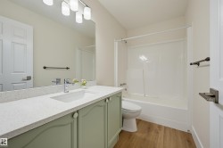 Bathroom with a built-in vanity featuring a light green finish, integrated sink, and a speckled white countertop - 