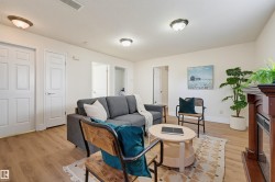 Wood-finish flooring throughout, bright white walls, and flush-mount ceiling lighting - 