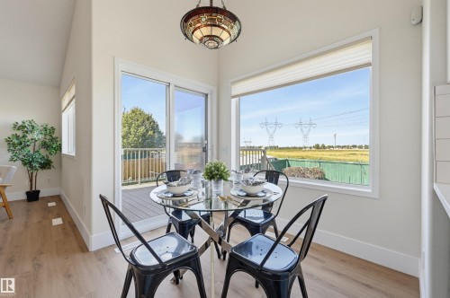 Wood-finish flooring, white walls, decorative ceiling light fixture, large sliding glass door, and expansive window - 839 Blacklock Way Sw, Edmonton, AB 