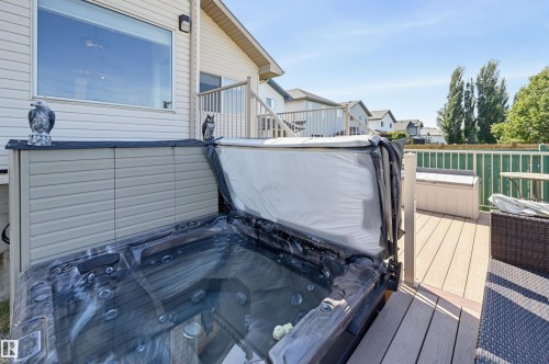 Composite deck with integrated spa, white railing, and exterior siding - 839 Blacklock Way Sw, Edmonton, AB 