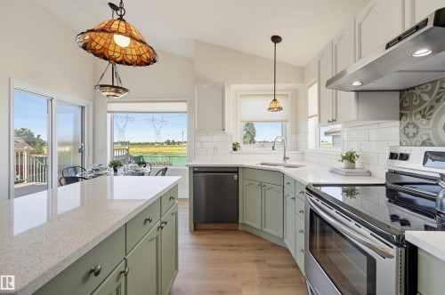 Kitchen featuring light-toned cabinetry, light-toned countertops, and wood-finish flooring - 839 Blacklock Way Sw, Edmonton, AB 