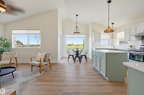 Vaulted ceilings, wood-finish flooring, abundant natural light, kitchen island with light green cabinetry, and white subway tile backsplash - 839 Blacklock Way Sw, Edmonton, AB 