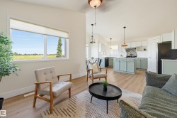 Open-concept living space featuring wood-finish flooring, recessed lighting, and a kitchen with an island, pendant lights, and a tiled backsplash - 