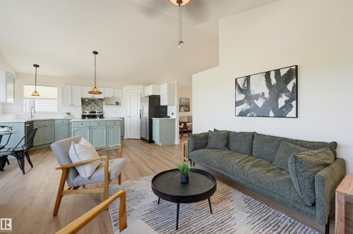 Vaulted ceilings, wood-finish flooring, and a kitchen featuring a tile backsplash, white countertops, and stainless steel appliances - 839 Blacklock Way Sw, Edmonton, AB 