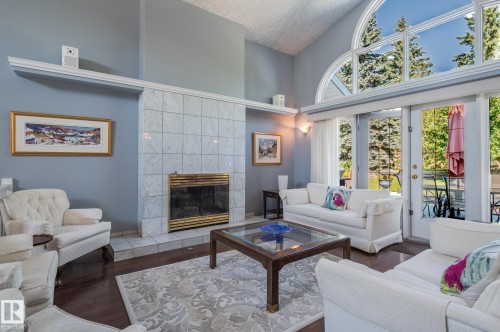 Vaulted ceiling, full-height tile fireplace, hardwood flooring, and French doors with transom windows - 8 Edgemont Point(E), St. Albert, AB 