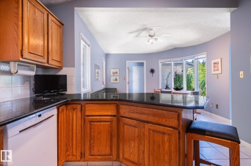 Wood-finish cabinetry with dark countertops - 8 Edgemont Point(E), St. Albert, AB 