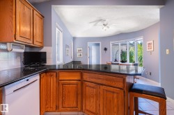 Wood-finish cabinetry with dark countertops - 
