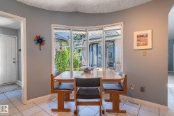Bay window with exterior landscaping, light gray walls, and white tile flooring - 