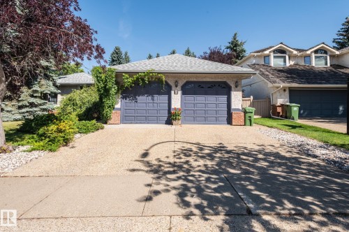 Attached two-car garage with panel doors, brick accents, and exterior lighting - 8 Edgemont Point(E), St. Albert, AB 