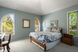 Arched windows, light blue wall paint, and gray carpeting - 