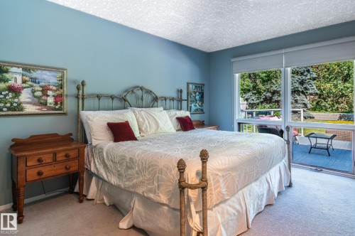 Carpeted flooring, light blue wall paint, and direct deck access with exterior landscaping - 8 Edgemont Point(E), St. Albert, AB 