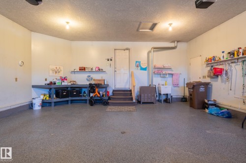 Spacious garage with textured flooring, a utility sink, and built-in shelving - 8 Edgemont Point(E), St. Albert, AB 