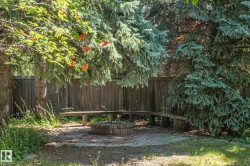 Private outdoor area with a wood privacy fence, integrated wooden bench seating, and a built-in fire pit - 