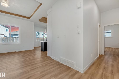 Wood-finish flooring throughout, white walls, and a recessed ceiling design with wood accents - 32 Dalquist Bay, Leduc, AB 