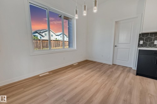 Wood-finish flooring, white walls, large window, modern pendant lighting, geometric tile backsplash - 32 Dalquist Bay, Leduc, AB 