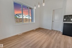 Wood-finish flooring, white walls, large window, modern pendant lighting, geometric tile backsplash - 