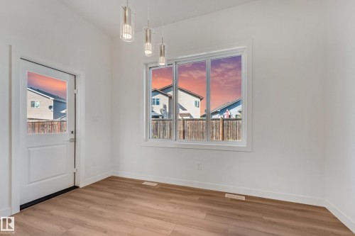 Wood-finish flooring, white walls, and contemporary pendant lighting fixtures - 32 Dalquist Bay, Leduc, AB 