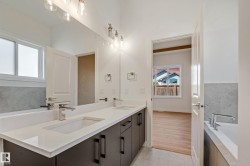 Dual vanity with undermount sinks, stone countertop, and dark cabinetry - 