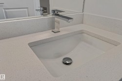 Integrated rectangular sink with polished chrome faucet and speckled light-toned countertop - 