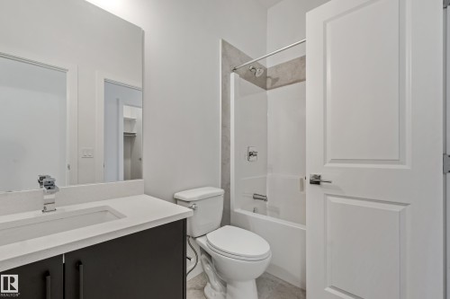 Integrated vanity with a rectangular basin sink, chrome faucet, and dark wood-finish cabinetry - 32 Dalquist Bay, Leduc, AB 