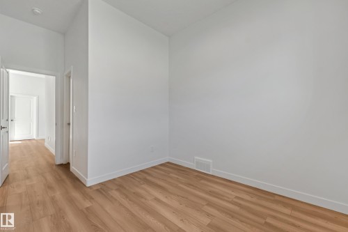 Wood-finish flooring throughout, bright white walls, and white trim - 32 Dalquist Bay, Leduc, AB 