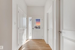 Entryway featuring a paneled door with decorative glass, a sidelight, and wood-finish flooring - 