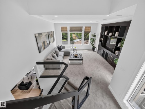 Loft space featuring a dark wood built-in media center with open shelving and cabinet storage - #59 10550 Ellerslie Rd Sw, Edmonton, AB - Indoor