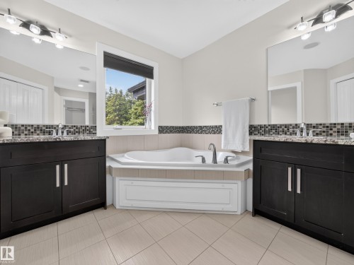 Corner soaking tub with deck-mounted fixtures - #59 10550 Ellerslie Rd Sw, Edmonton, AB - Indoor Photo Showing Bathroom