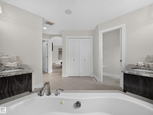 White soaking tub with polished chrome fixtures - #59 10550 Ellerslie Rd Sw, Edmonton, AB - Indoor Photo Showing Bathroom