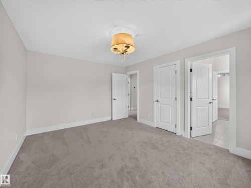 Spacious room featuring neutral carpeting, light gray wall paint, and white baseboards - #59 10550 Ellerslie Rd Sw, Edmonton, AB - Indoor Photo Showing Other Room