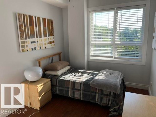 Hardwood-finish flooring, light grey wall paint, and a large window with white blinds - #407 11103 84 Av Nw, Edmonton, AB 